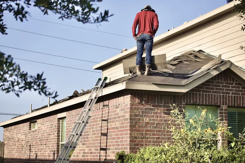 Professional roofer working on a residential roof in Scandia
